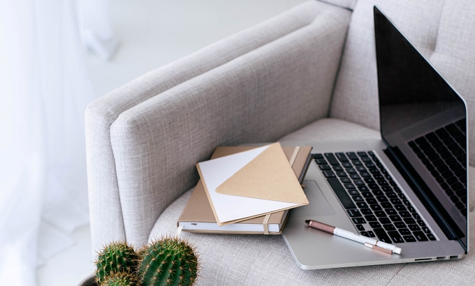 Decorative image of couch and a little table with a cactus, a notebook, and a laptop - 9 Reasons for Outsourcing in Your Author Business