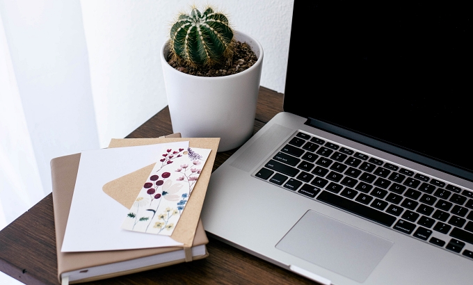 Decorative image of side-table with a cactus, 1 notebook, and a laptop - 9 Reasons for Outsourcing in Your Author Business